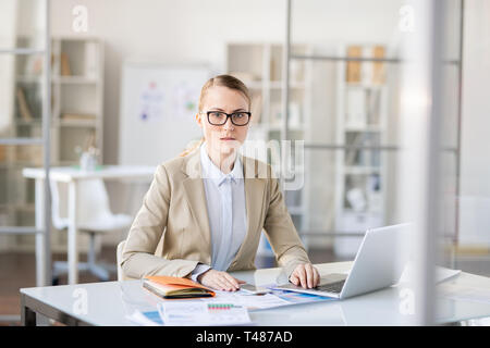 Puzzled businesswoman doing paperwork Stock Photo