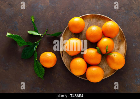 Oranges with leaves on dark background, top view Stock Photo