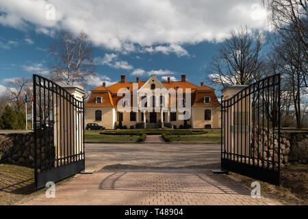 LIEPUPE, LATVIA - APRIL 13, 2019: Liepupes Muiza manor in beautiful sunny Spring weather with blue sky and clouds Stock Photo