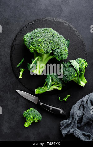Fresh broccoli florets on black background, top view Stock Photo
