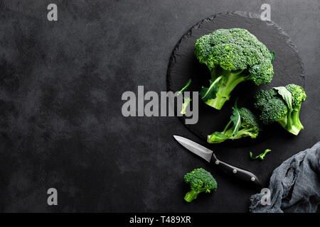 Fresh broccoli florets on black background, top view Stock Photo