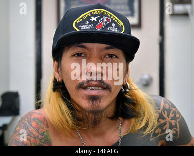 Young Thai tattoo artist poses for the camera. Stock Photo