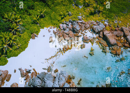 Anse Marron beach, Seychelles - tropical hidden secret beach.White sand beach with pure transparent turquoise ocean water and granite rocks - aerial Stock Photo