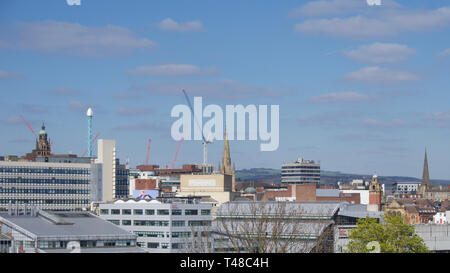 View of Sheffield City Centre across valley from Park Hill on a bright day with a few clouds in the blue sky Stock Photo