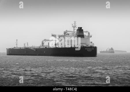 Black And White Photo Of The Supertanker, (Crude Oil Tanker), AQUAPUELCHE, Anchored In The Port Of Long Beach, California, USA. Stock Photo