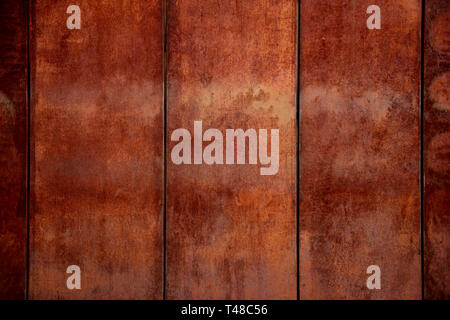 Rough textured rusty corroded weathered metal wall with vertical sections and lines Stock Photo