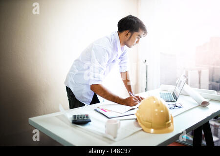 Architect working on blueprint.engineer inspective in workplace - architectural project, blueprints,ruler,calculator,laptop and divider compass. Const Stock Photo