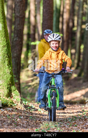 Young boy cycling with his mountainbike on forest trail Stock Photo