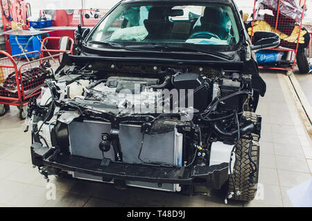 wires from the car wiring lies in the cabin of the dismantled car with connectors and plugs, a view through the window inside the battered car. Stock Photo