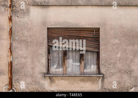 Old house with broken window shutters Stock Photo
