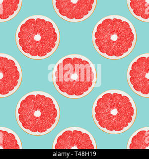 Grapefruit seamless pattern Big pink grapefruit halves on a light blue background Stock Photo