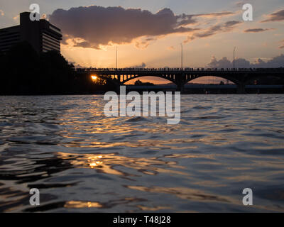 As the sun sets, hundreds of onlookers wait on bats to emerge from the Congress Avenue bridge in Austin, Texas Stock Photo