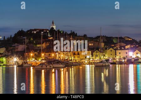 View of the town with sailing boats and lights reflecting in the water, evening mood, Primosten, Croatian Adriatic coast, Dalmatia, Croatia Stock Photo