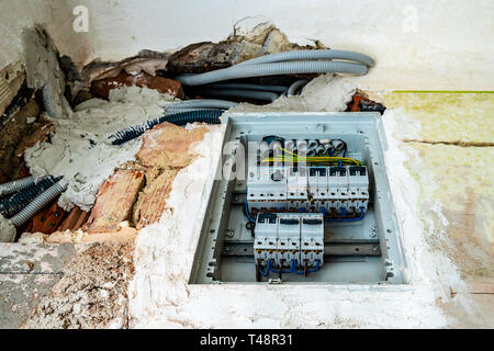 Electrical Power Current Fuse Under Construction with Grey Colored Electricity Lines PVC Hoses Installed in the Wall of an Apartment Stock Photo