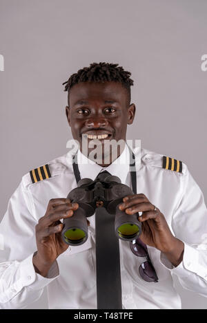 London UK, April 2019.  Young airline pilot using a pair of binoculars. Stock Photo