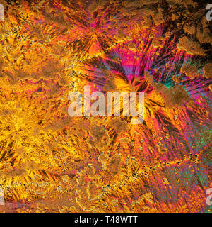 Microscopic view of vitamin C crystals forming intricate colorful patterns, creating a vivid abstract landscape of texture, colour and light Stock Photo