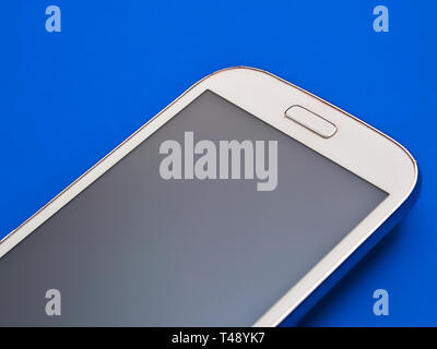 Isolated white cell phone on blue background. Stock Photo