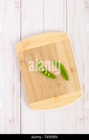 direct overhead shot of snap peas on a wooden cutting board Stock Photo