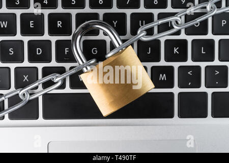 Padlock with chain on a laptop computer keyboard. Cyber security abstract concept. Stock Photo