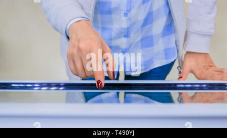 Woman using interactive touchscreen display kiosk Stock Photo