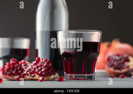 Pomegranate juice in a glass on gray background. Stock Photo