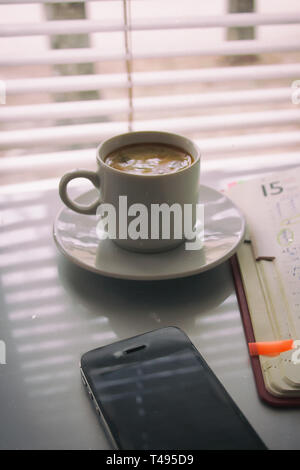 Silhouettes of sunrise morning coffee with a note and a telephone Stock Photo