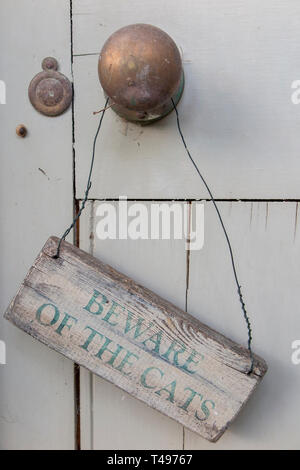 A sign warning to 'Beware of the Cats' on a weathered outside door Stock Photo