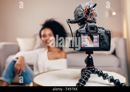 Close up of a DSLR camera mounted on a tripod. Vlogger filming a content. Stock Photo