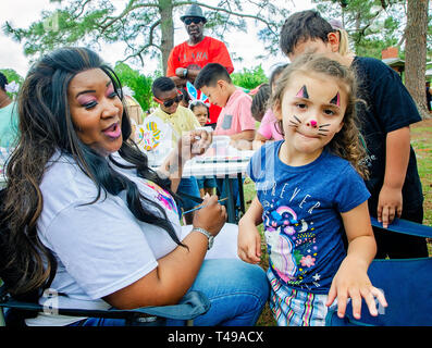 A girl shows off the Easter bunny whiskers she just had painted on her face at an Easter egg hunt at Langan Park, April 13, 2019, in Mobile, Alabama. Stock Photo