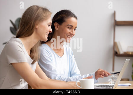 Two happy businesswomen work together collaborate on laptop in office Stock Photo