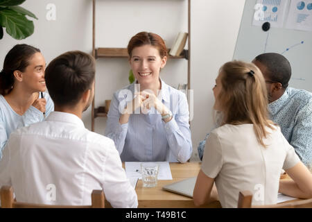 Happy female leader and diverse business team having friendly conversation Stock Photo