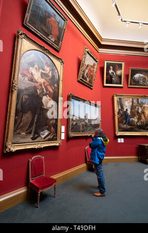 Man looking at a painting inside the Scottish National Gallery art museum, Edinburgh, Scotland, United Kingdom, Europe