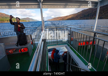 Tourist taking selfie aboard a cruise boat navigating on Loch Ness, Scottish Highlands, Scotland, UK, Europe Stock Photo