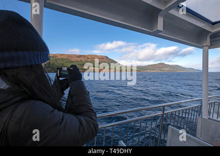 Tourist on a cruise boat tour of Loch Ness takes pictures in search of monster Nessie, Scottish Highlands, Scotland, UK, Europe Stock Photo