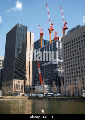 High rise buildings in construction with cranes on top of roof in Tokyo, Japan Stock Photo