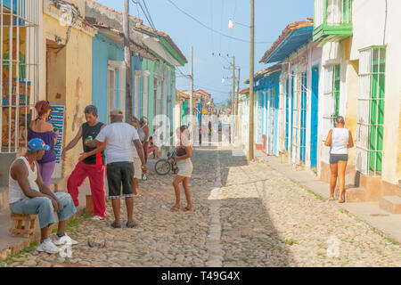 TRINIDAD CUBA JULY 2  2012; People interacting in typical Cuban village street narrow and lined on both sides with homes and doorways. Stock Photo