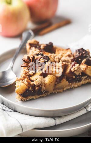 Piece of vegan apple pie with cinnamon and dates. Vegan food concept. Stock Photo