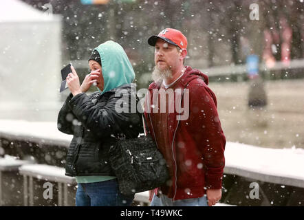 Chicago, USA. 14th Apr, 2019. People stand in snow in Chicago, the United States, on April 14, 2019. A snowfall hit Chicago on Sunday. Credit: Wang Ping/Xinhua/Alamy Live News Stock Photo