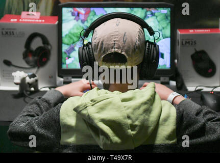 Berlin, Germany. 12th Apr, 2019. A child plays a computer game with headphones on his ears at the Gamefest in the Kulturbrauerei as part of Gamesweekberlin 2019. The international network meeting of the games industry will take place from 08.04. to 14.04.2019. Credit: Jens Kalaene/dpa-Zentralbild/dpa/Alamy Live News Stock Photo