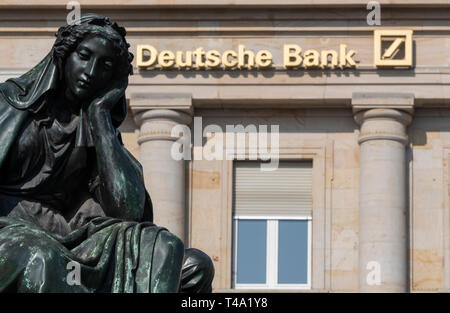 15 April 2019, Hessen, Frankfurt/Main: A sculpture in front of a Deutsche Bank branch. Financial experts consider a merger of the bank with Commerzbank to be possible. Photo: Boris Roessler/dpa Stock Photo