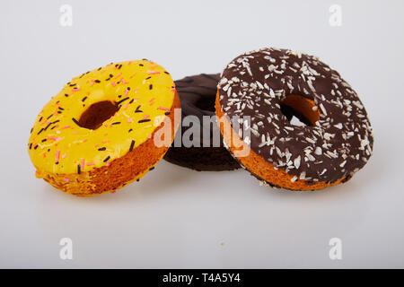 assorted donuts with chocolate frosted, yellow glazed and sprinkles donuts. Sweet and colourful doughnuts Stock Photo