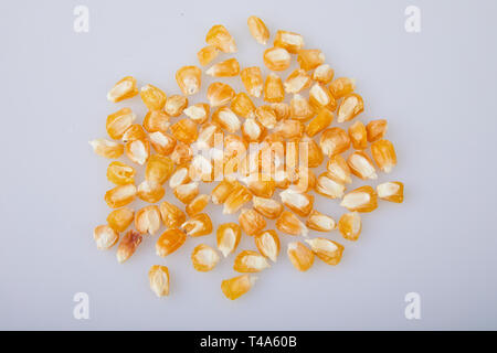 Yellow dry selective corn seeds isolated on white background. Gardening and agriculture. Selected seeds for planting in the agricultural field Stock Photo