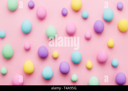 Pastel colored Easter eggs pattern on pink background. Colorful holiday card Happy Easter. Minimal style, flat lay. Stock Photo