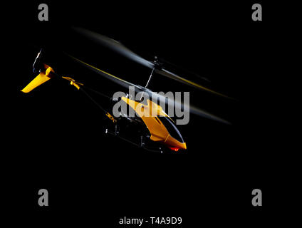 Flying RC helicopter on black Stock Photo