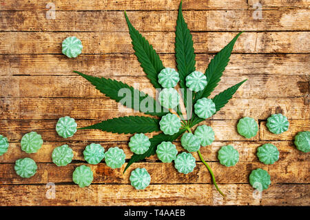 Cannabis bonbons and marijuana leafs on a table top view Stock Photo