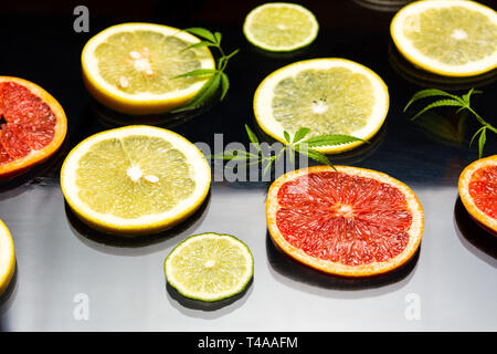 Sliced lemon and grapefruit on a dark table Stock Photo