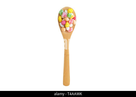 Slices of dried fruit, nuts and candy in the glaze on a wooden spoon. White isolate Stock Photo