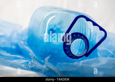 Big transparent opened water cane lying on thin plastic material Stock Photo