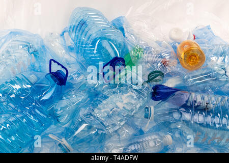 Bottles of different sizes and colors being placed together on blue plastic mat Stock Photo