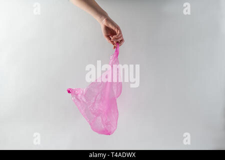 Hand holding purple transparent bag made of cheap thin plastic Stock Photo